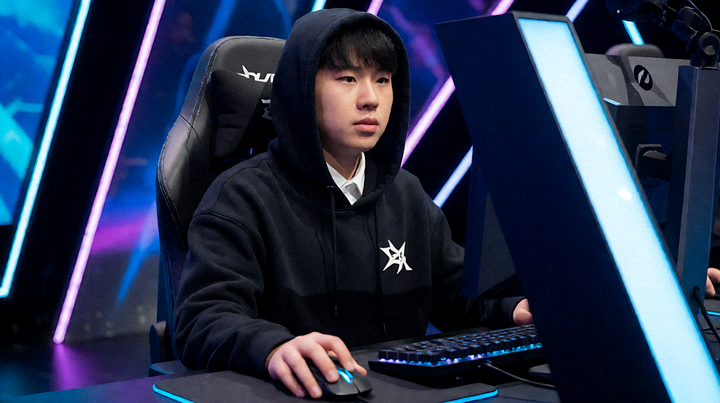 电竞赛事舞台灯光亮起，选手在比赛席位上准备开赛